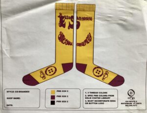 Illustration of a sock design: yellow socks with brown lettering which reads "Eesasox Expereince" and "are you experienced" (referencing Jimi Hendrix).
